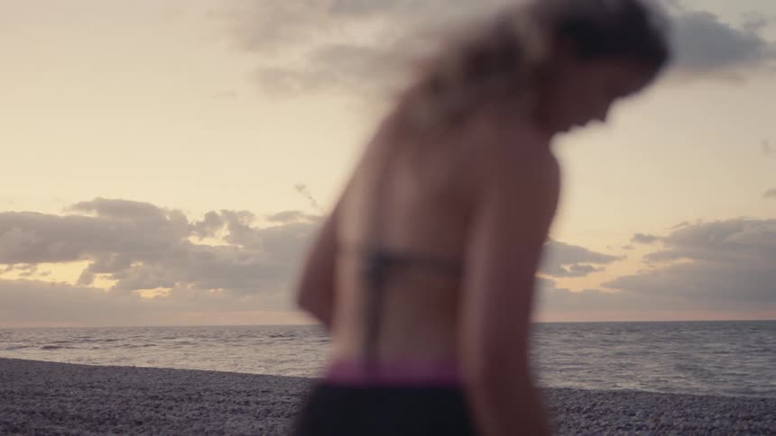 Blurred woman walking on the beach at dusk