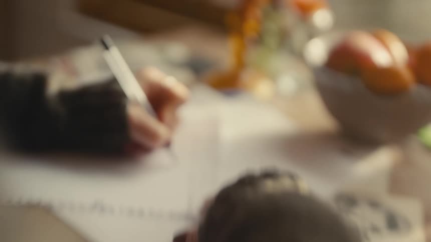 A person writing with a pen on paper