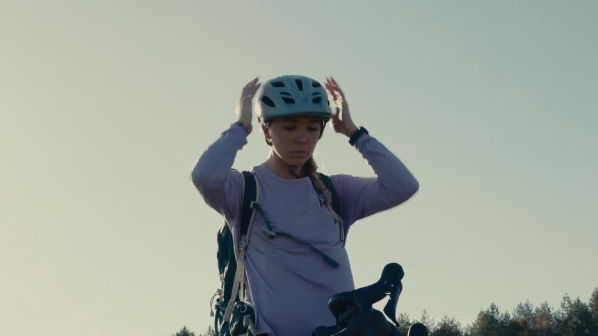 Cyclist adjusting the helmet before riding