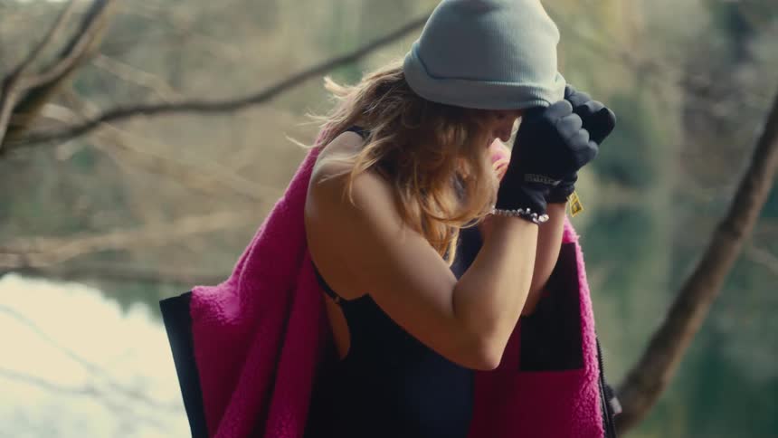 The hiker puts on her hat
