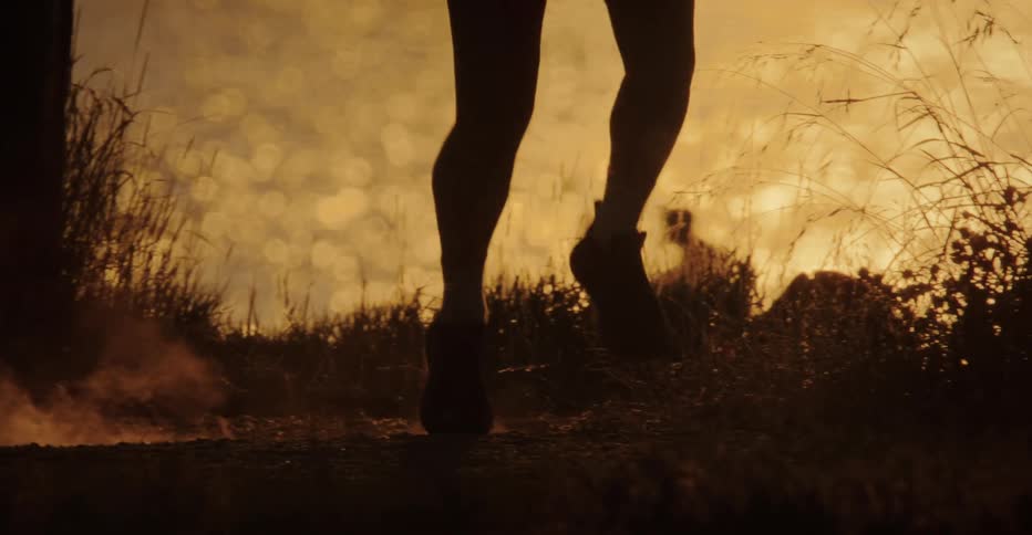 Runners legs moving along a trail at sunset