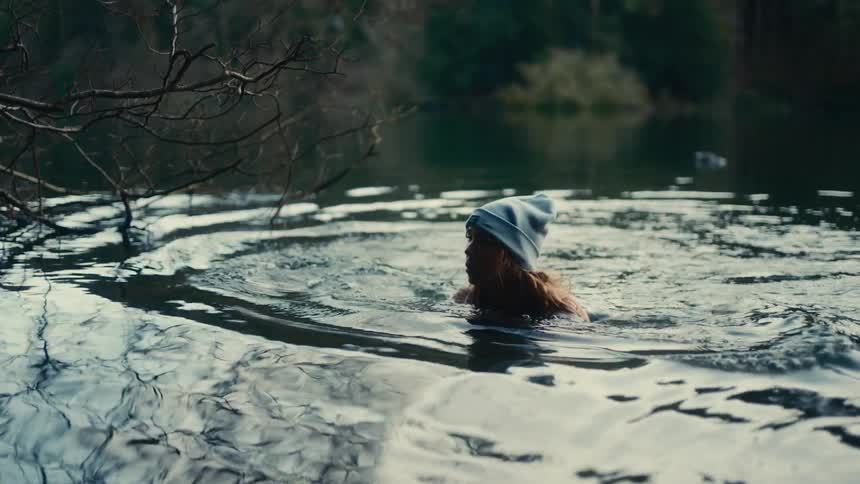 A woman swimming in a lake outdoors