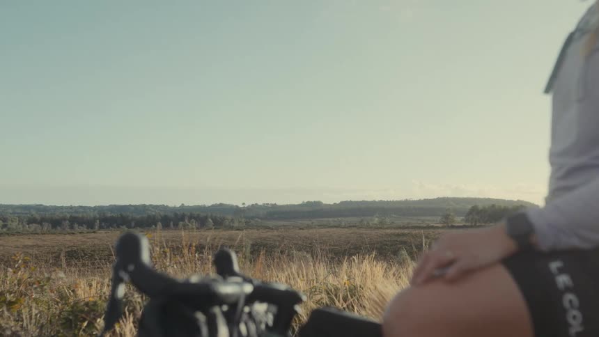 Teenage girl sitting on her bicycle in a rural field