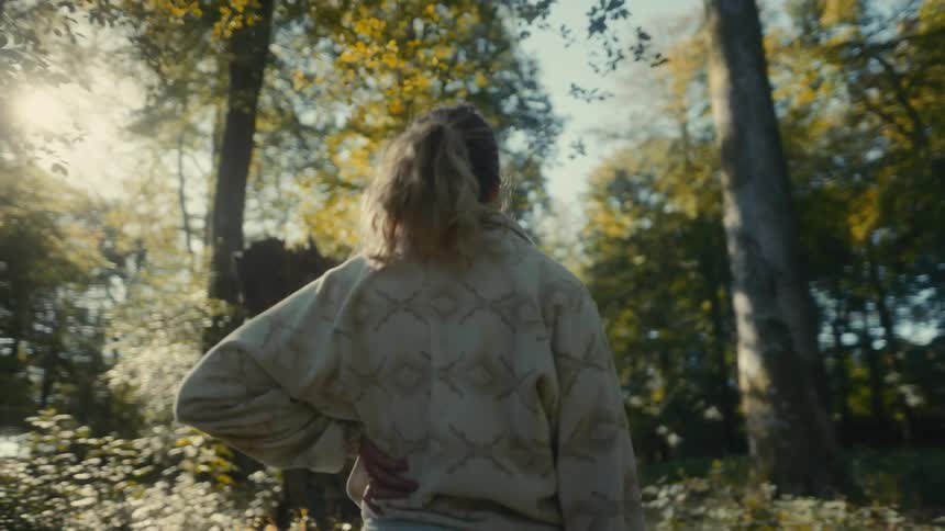 A woman standing in a forest on a sunny day