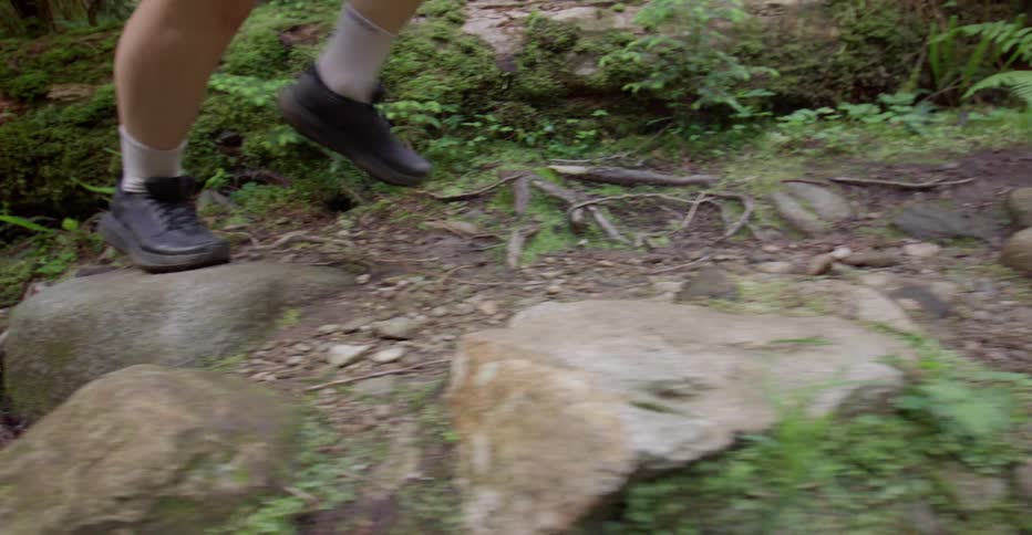 The person is running through the woods