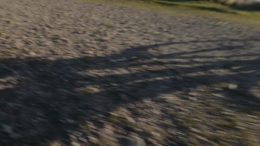 Shadow moving across the ground of a person riding a bicycle