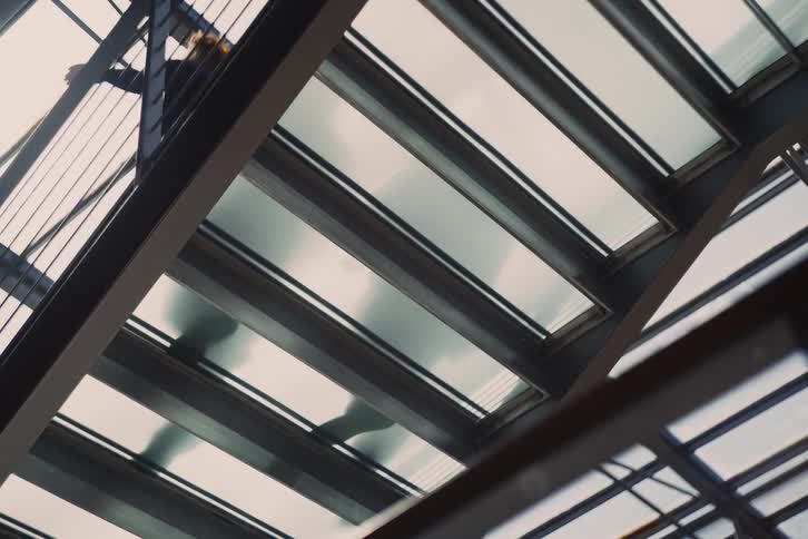 Person walking on a glass walkway viewed from below