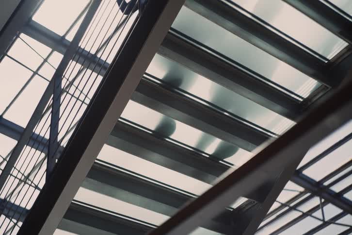 Two people climb a staircase with transparent steps during the daytime