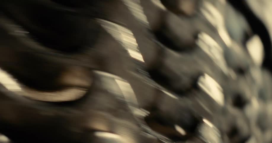A fastmoving blur of metallic reflections resolves into a sharp detailed view of a bicycles oily gear cassette as the spinning motion abruptly stops