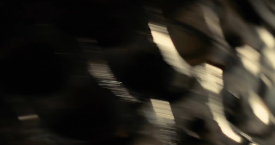 The dark metallic teeth of a bicycle cassette spin rapidly