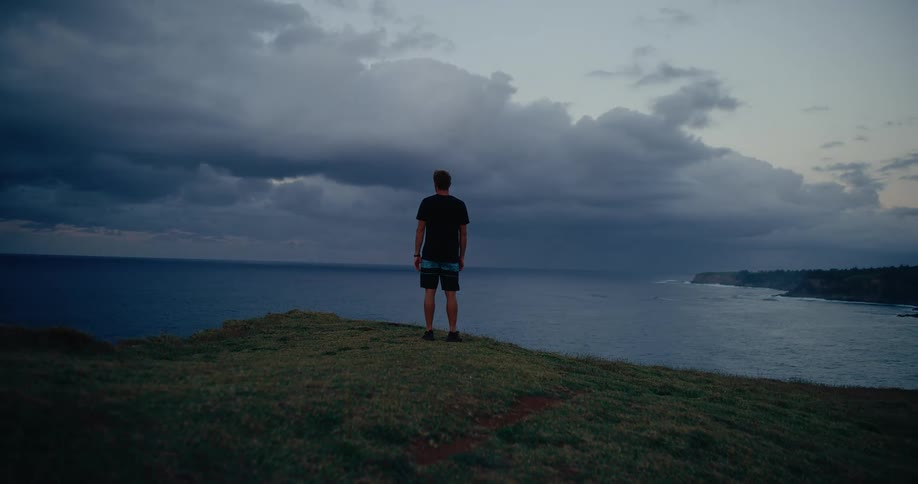 A young man standing outdoors at the ocean coast during daytime