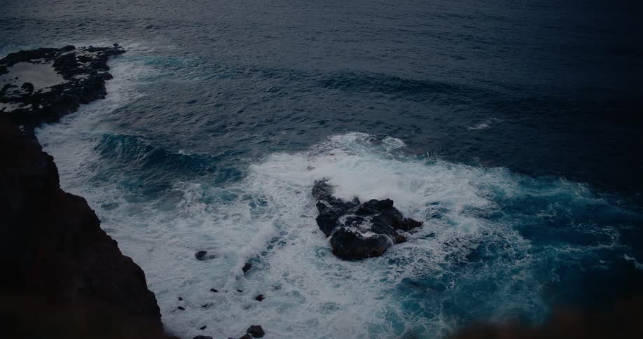 Ocean seen from the top of a cliff on the coast outdoors during dusk or dawn
