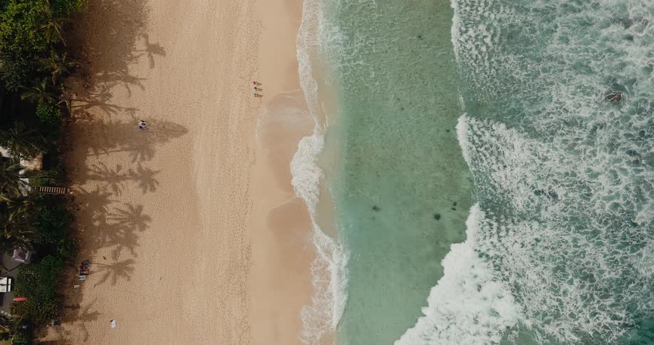 Waves hitting the beach shoreline on a sunny day