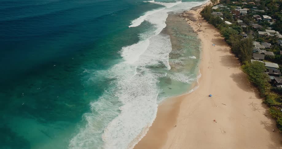 Stretch of lightsand beach beside bluegreen sea