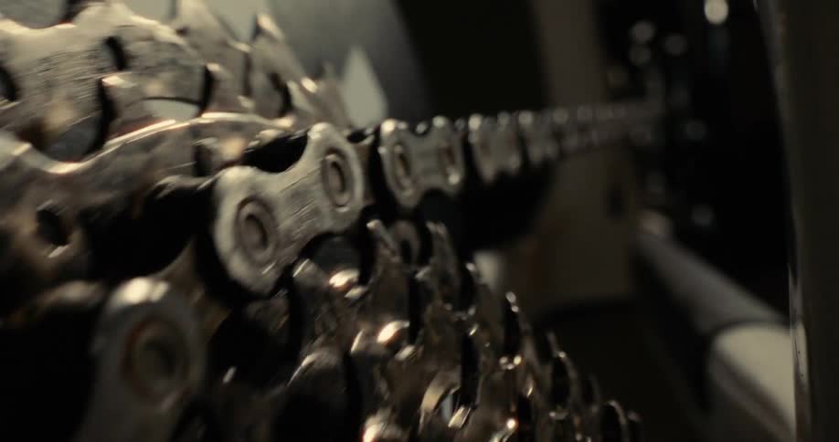Close up of an operating bicycle roller chain and gear system