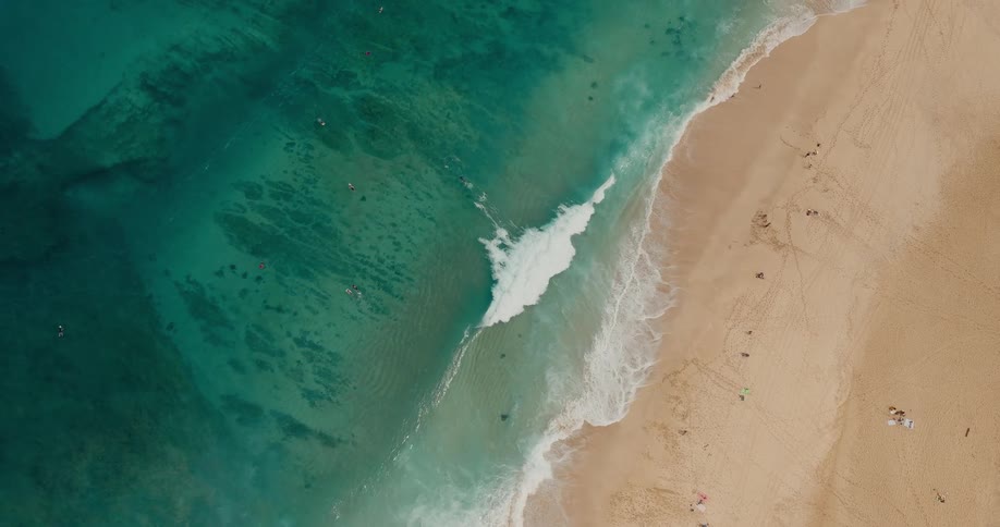 Aerial view of waves rolling in to shore and over the beach