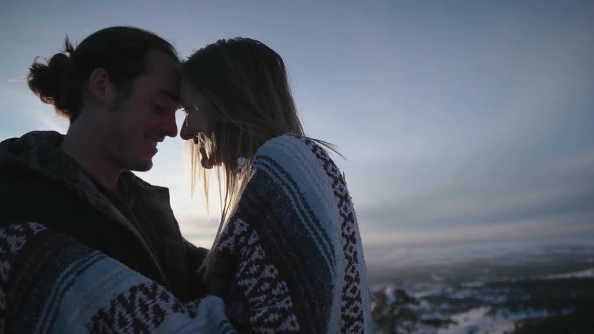 Two people hug and butt heads at dawn