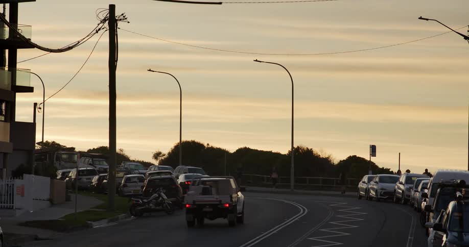 Busy street with parked cars under an orange sky