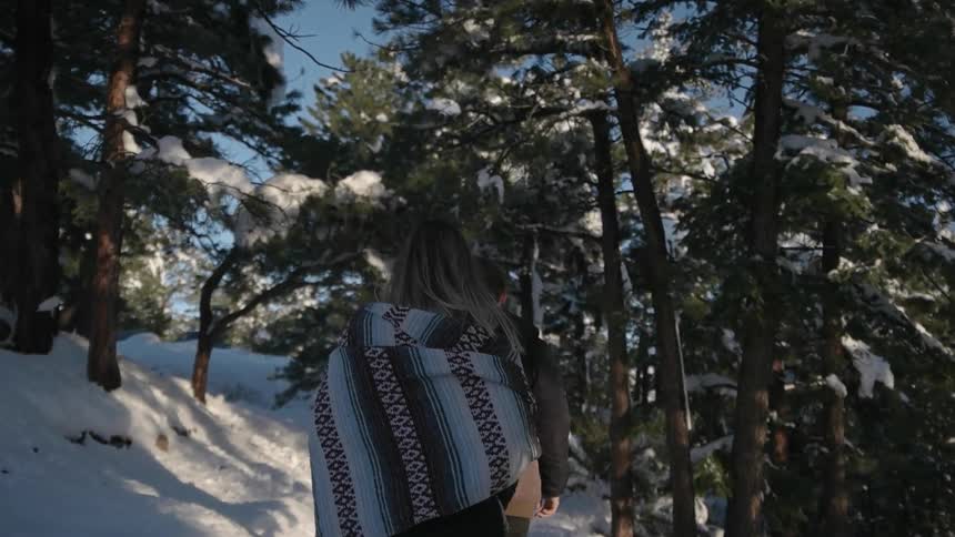 Woman walks up a snowy hillside