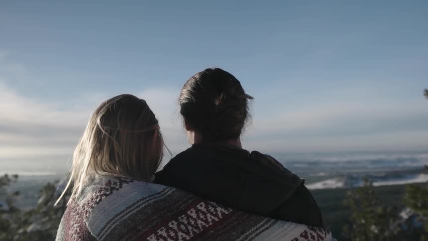 Two women hug on a mountain top