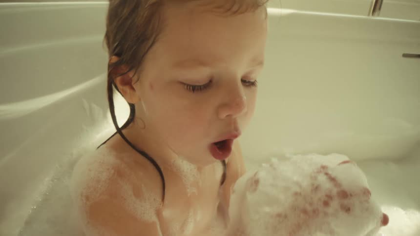 A girl taking a bath in a bathtub