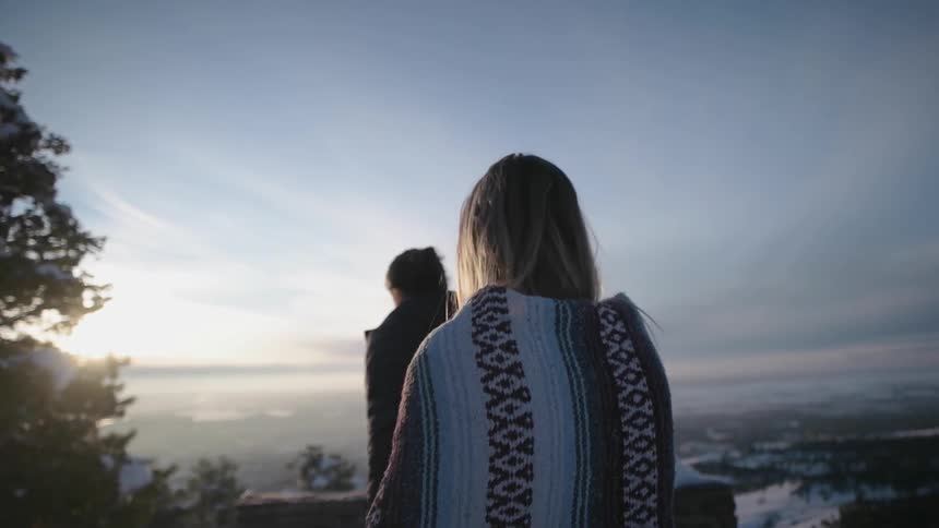 A man and woman walk outside on a snowy day