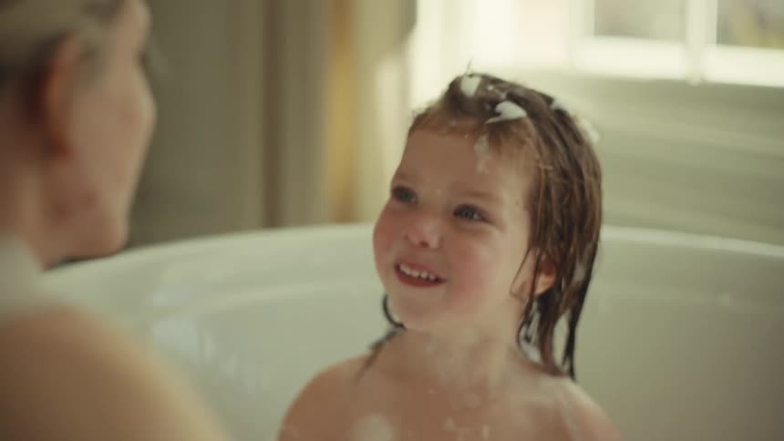 A mother giving her daughter a bath