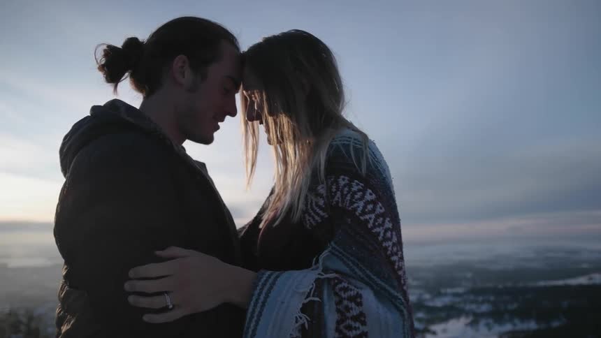 A man and woman hug on a mountain