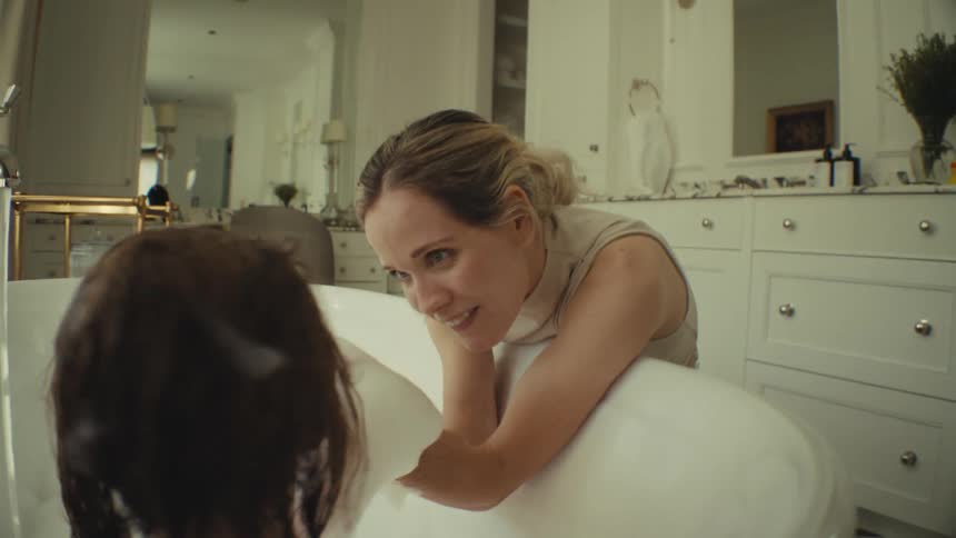 A mother giving her daughter a bath