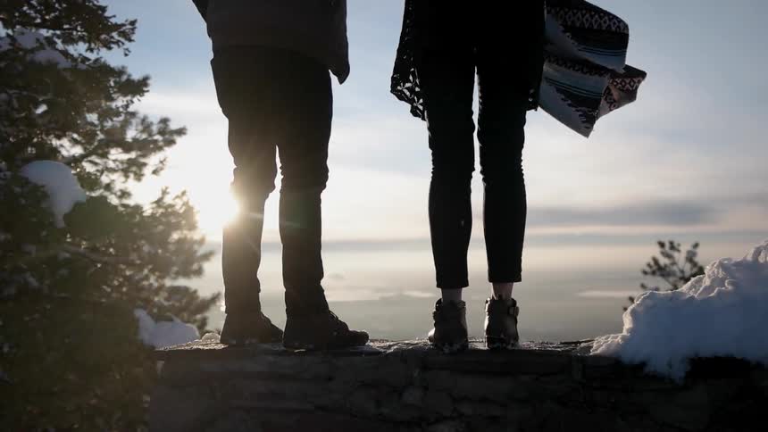 Two people stand on a cliff together