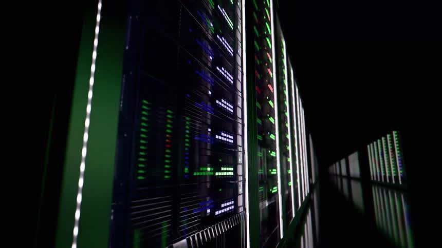 Server rack corridor with long rows of green indicators reflected on the dark floor