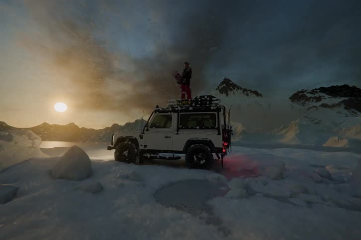 Timelapse of a woman with a snowboard standing on an off-road 4x4 as the winter sunset light changes over snowy mountains.