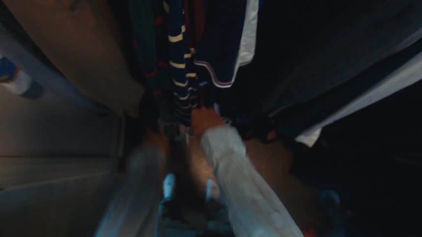 The man is getting dressed by the closet