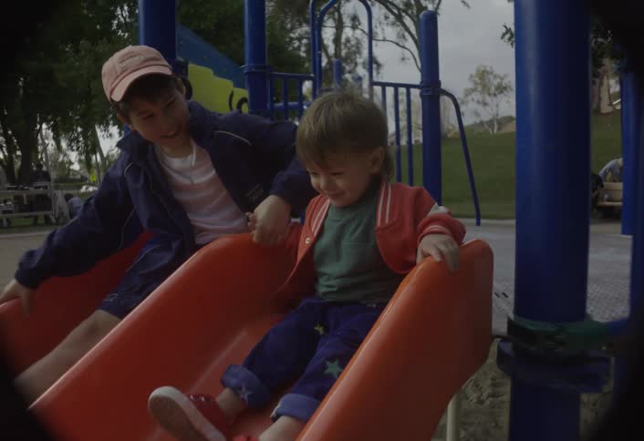 Children sliding together on a playground slide
