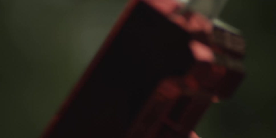 A close view of a person shooting dollar bills with two novelty shiny red guns