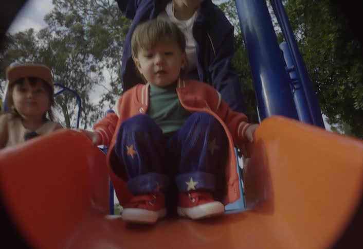 Some children playing on slides outdoors