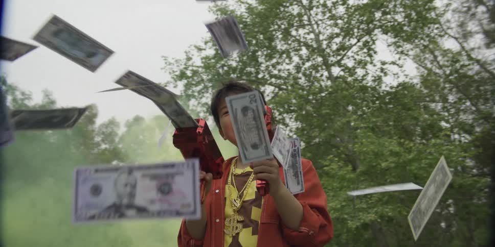 Child using two moneyshooting toy guns outdoors
