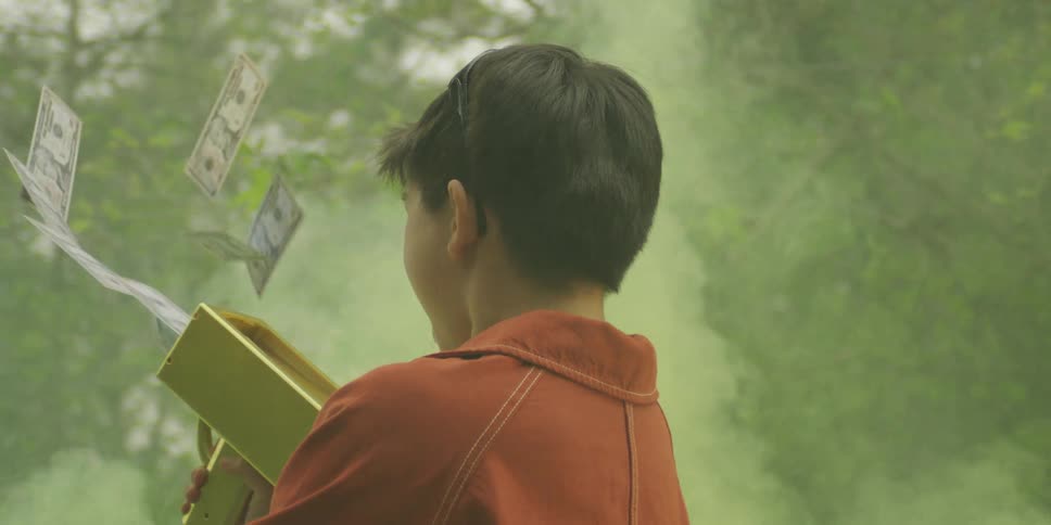 Child holding a goldcolored moneyshooting toy while looking upward