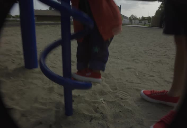Children walking beside a metal staircase in a playground