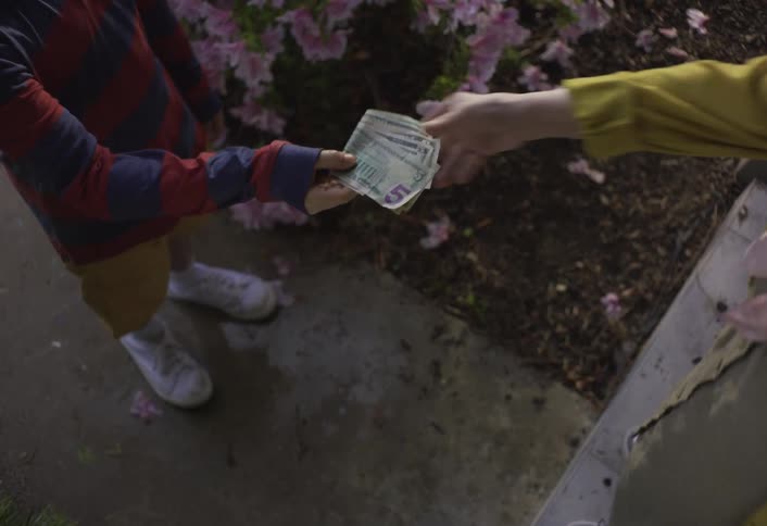 The boy hands cash to a person