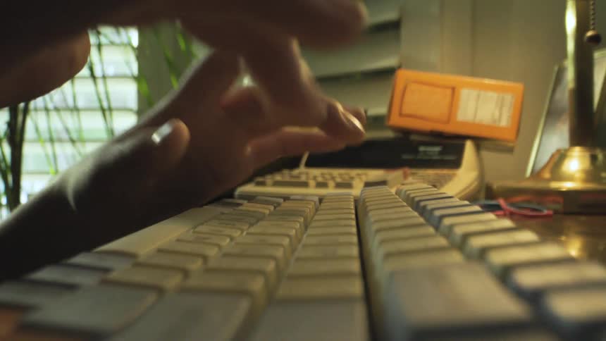 Hand typing on a mechanical keyboard on an office desk