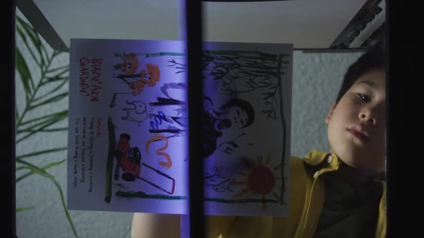 Boy scanning a colorful drawing on a home scanner
