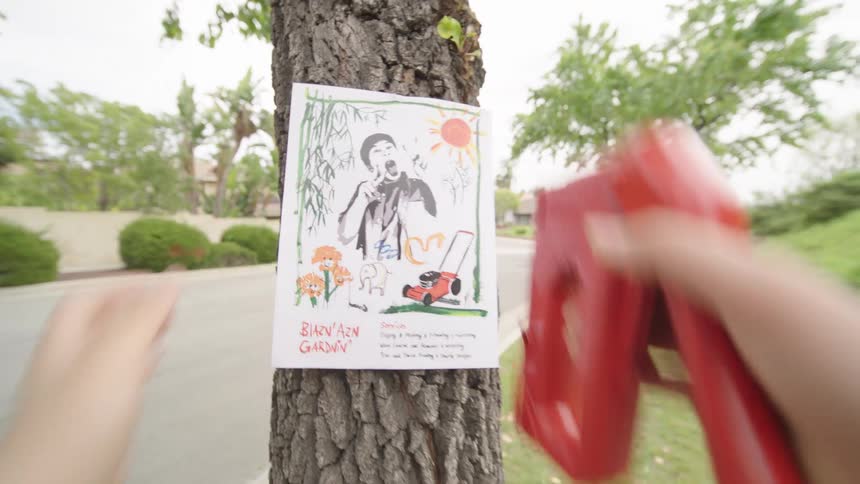 Illustrated flyer being stapled to a tree trunk in a residential area