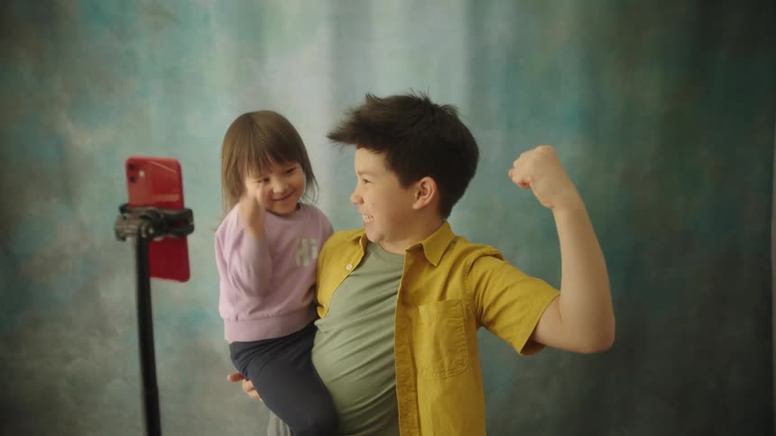 A young adorable brother and sister make funny faces together for a selfie