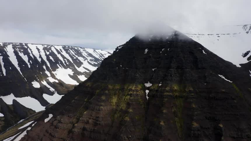 Snow on mountains with escarpment high in the clouds