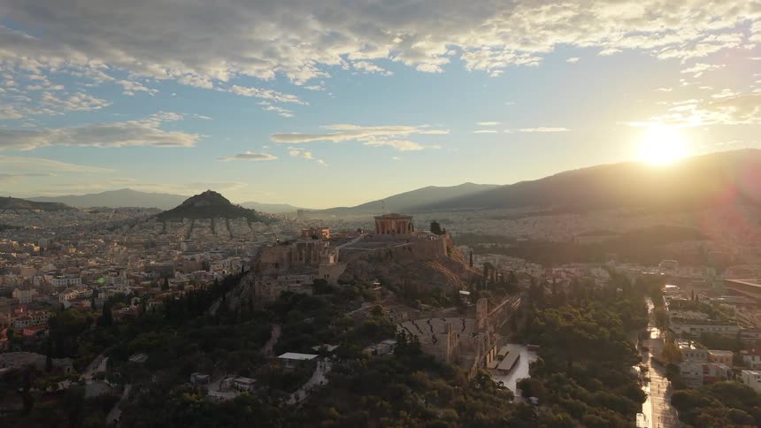 Ariel view of the acropolis rising above the city during a glowing sunset