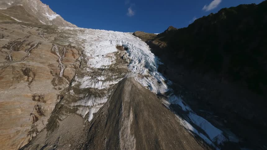 Glacier flowing between rocky slopes
