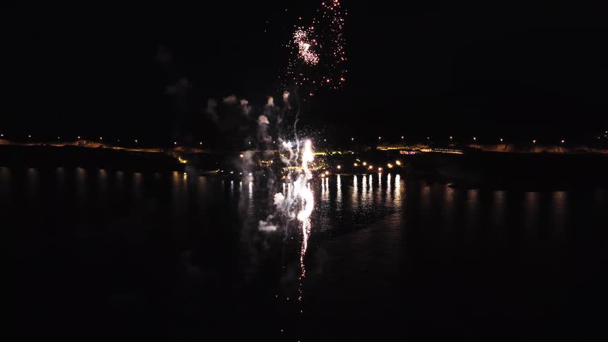 Fireworks reflecting on the water during a nighttime show