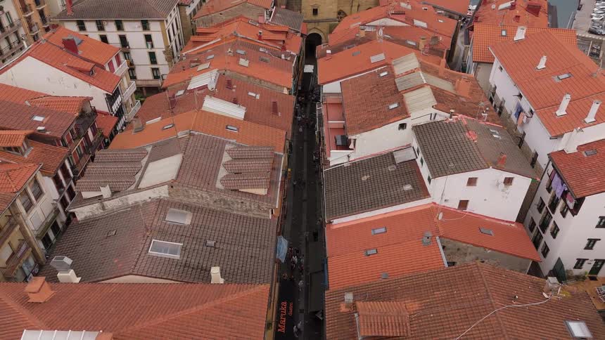 Aerial view of red rooftops lining the narrow streets of an old urban center