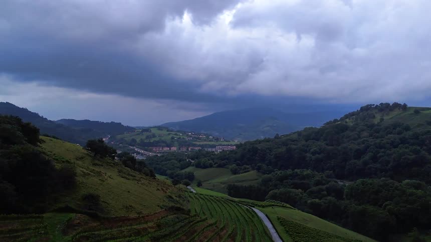 Hills and valleys on a rural area next to a village and a busy road with traffic outdoors during day time